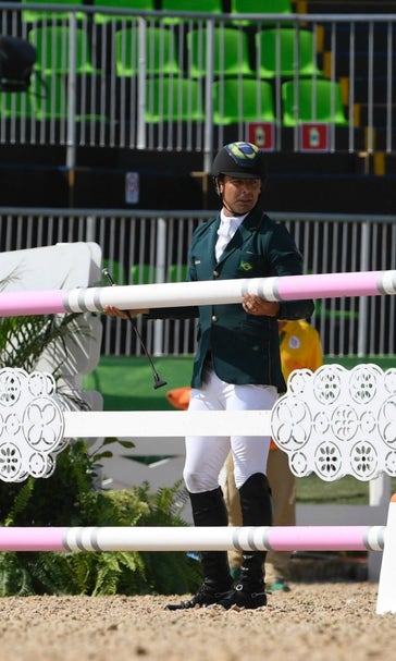Olympian gets thrown off his horse,  somersaults over gate